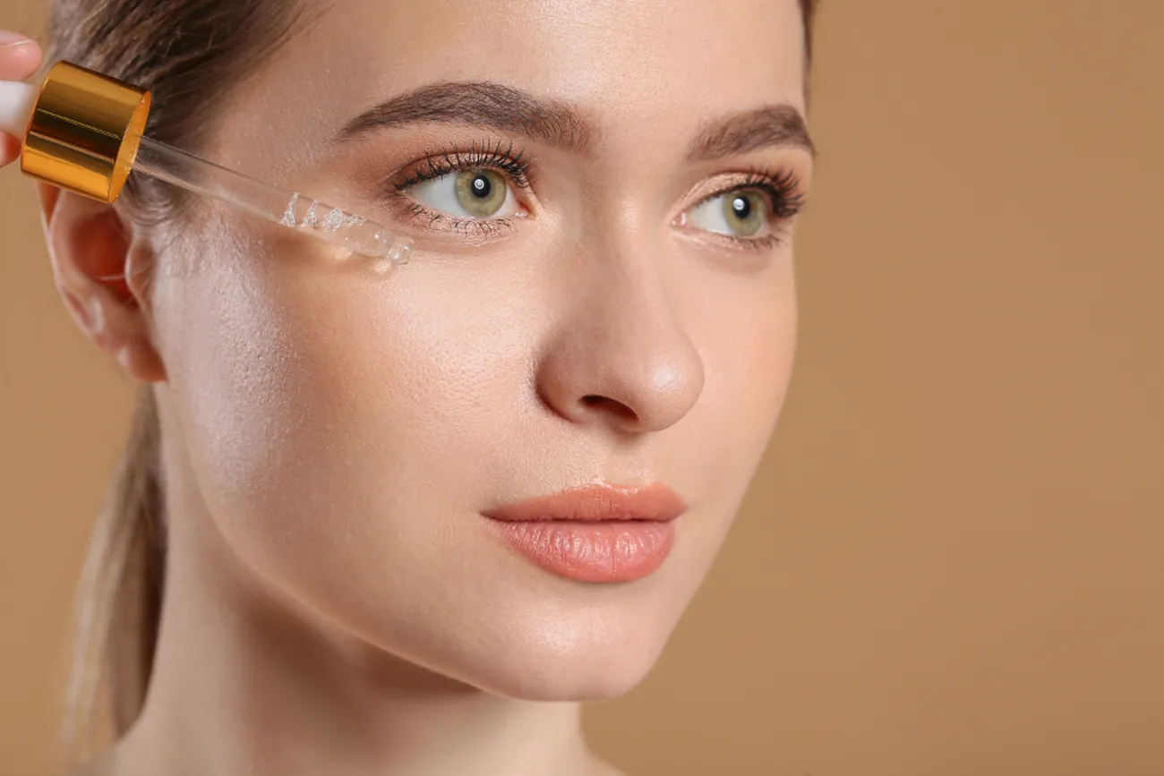 Cosmeticiană care aplică o mască facială unei cliente întinse pe pat