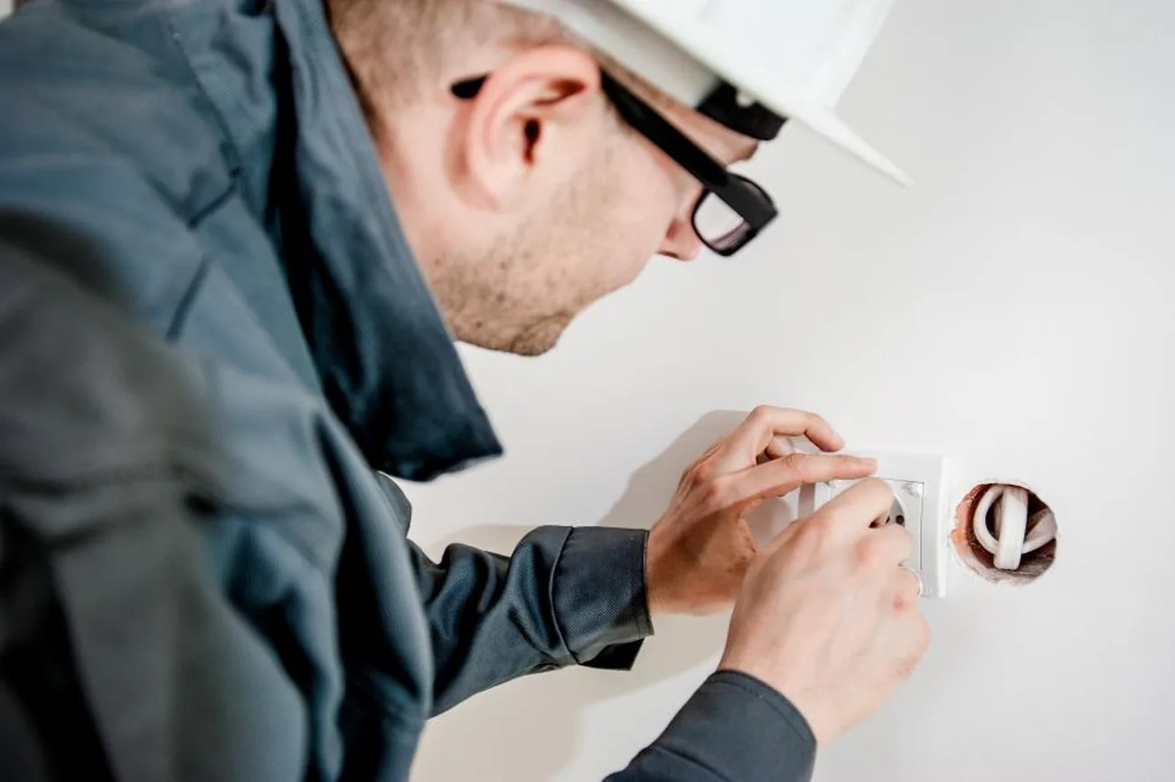 Instalator care montează o centrală termică de perete într-o bucătărie